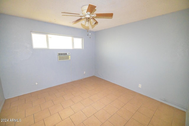 tiled empty room with ceiling fan and a wall mounted air conditioner