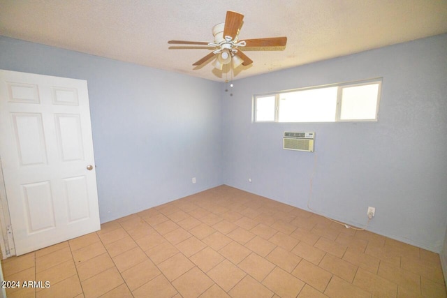 empty room with ceiling fan, a wall mounted air conditioner, and a textured ceiling