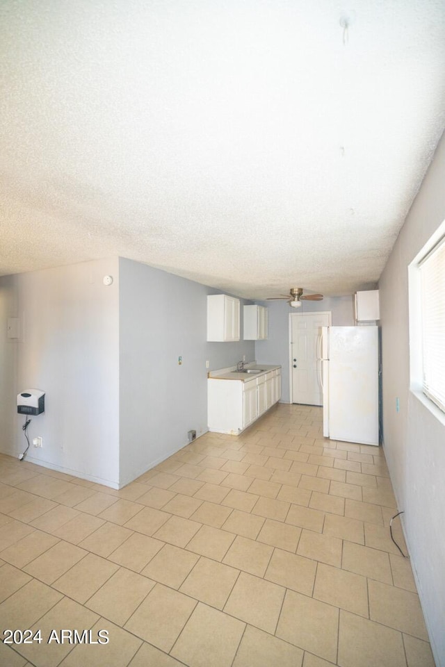 unfurnished living room featuring a textured ceiling, ceiling fan, and sink