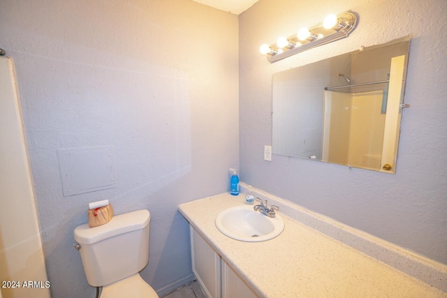 bathroom with walk in shower, toilet, and vanity