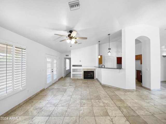 unfurnished living room with lofted ceiling, french doors, and ceiling fan