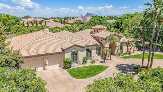 mediterranean / spanish-style home featuring a front yard and a garage