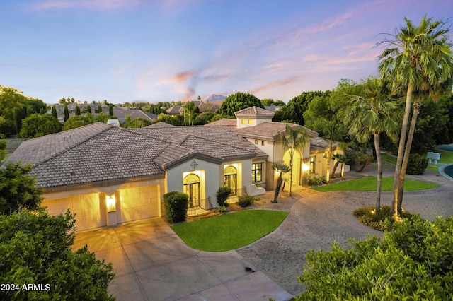 mediterranean / spanish home with a yard and a garage