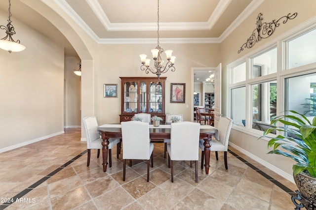 dining area with ornamental molding, a raised ceiling, and a notable chandelier