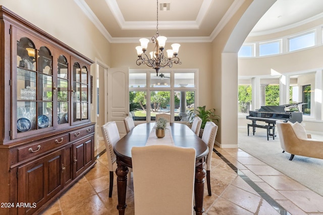 carpeted dining room featuring a tray ceiling and ceiling fan with notable chandelier