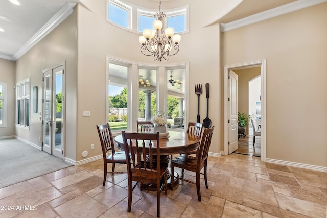 dining space with ceiling fan with notable chandelier, a towering ceiling, and crown molding