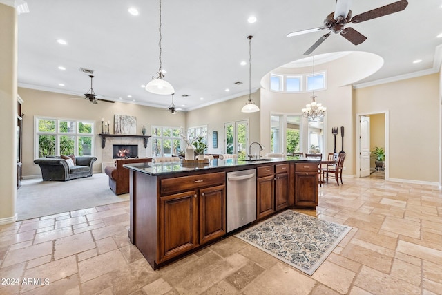 kitchen with stainless steel dishwasher, decorative light fixtures, a center island with sink, and sink