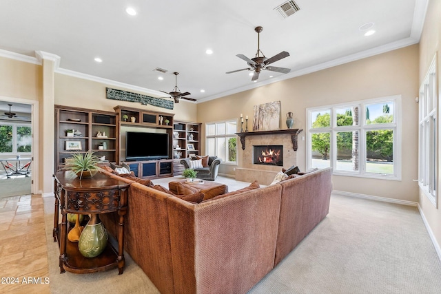 living room featuring ceiling fan, a premium fireplace, ornamental molding, and light carpet