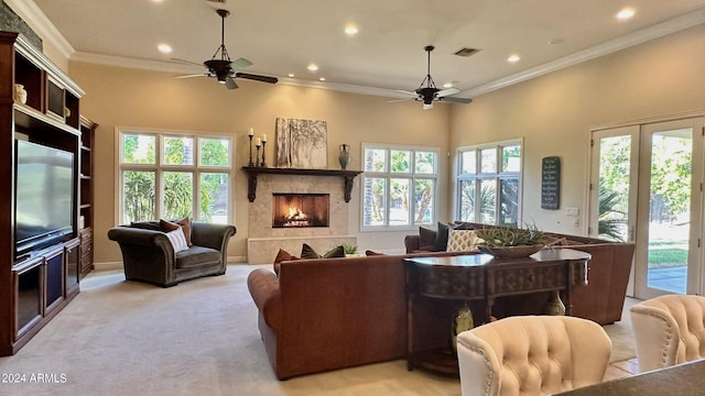 living room with ceiling fan, a healthy amount of sunlight, light colored carpet, and ornamental molding