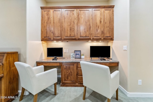 carpeted office featuring built in desk