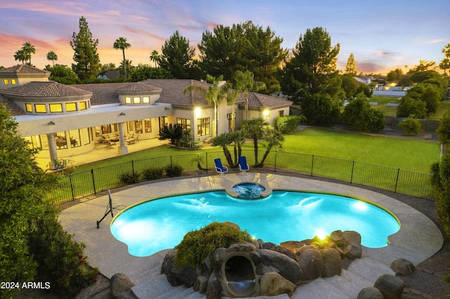 pool at dusk featuring a yard and a patio