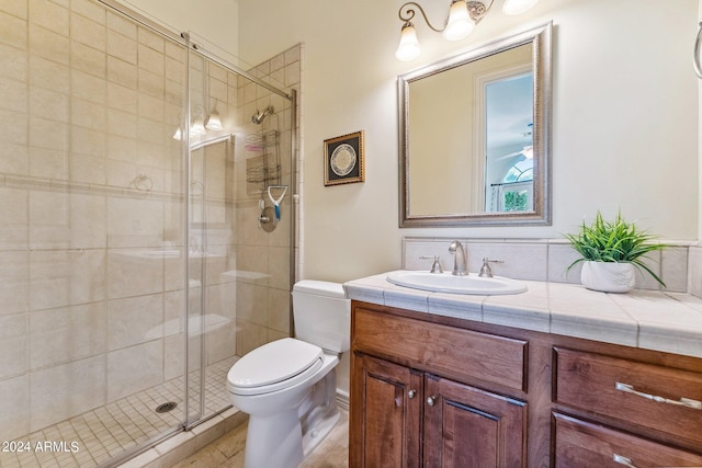 bathroom with tile patterned flooring, vanity, toilet, and an enclosed shower