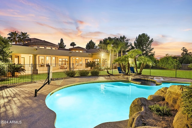 pool at dusk with a patio area