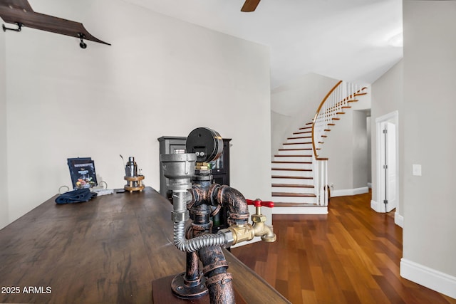 interior space featuring baseboards, ceiling fan, wood finished floors, and stairway