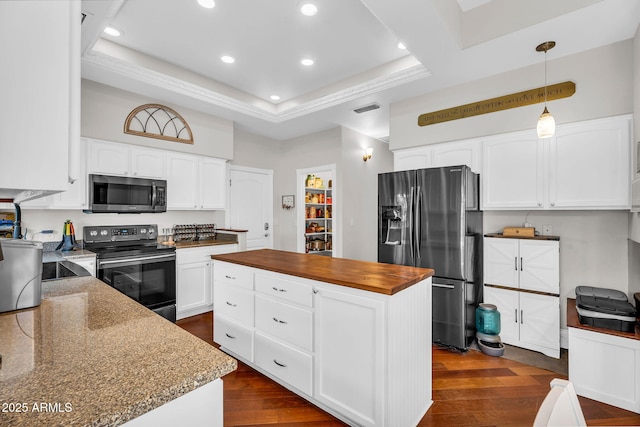 kitchen featuring appliances with stainless steel finishes, wooden counters, recessed lighting, a kitchen island, and visible vents