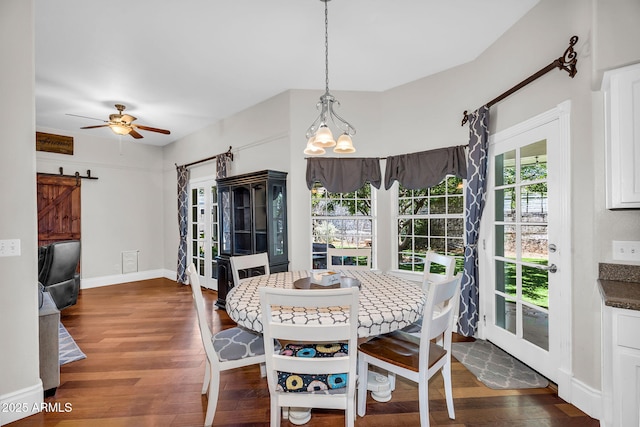 dining room with baseboards, a barn door, dark wood-style flooring, and ceiling fan
