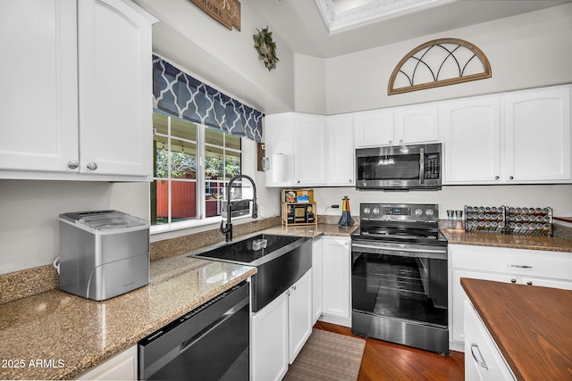 kitchen featuring a sink, dark stone counters, white cabinets, and stainless steel appliances