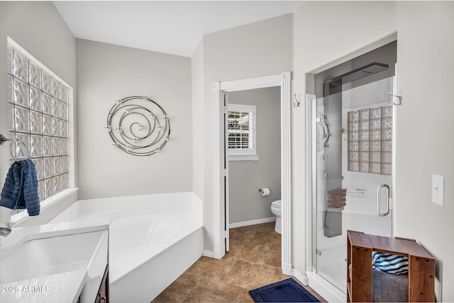 bathroom with a garden tub, baseboards, a stall shower, and toilet