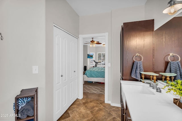 bathroom with vanity, baseboards, a ceiling fan, and connected bathroom