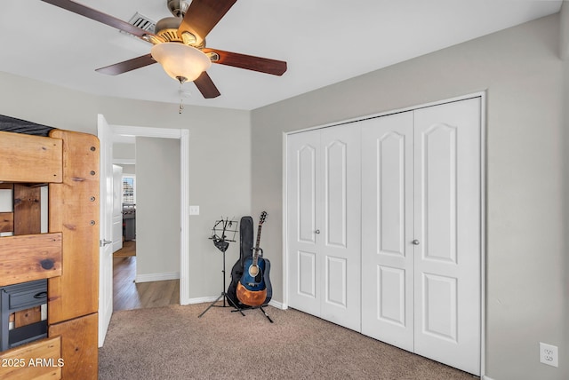 bedroom featuring carpet flooring, a ceiling fan, baseboards, visible vents, and a closet