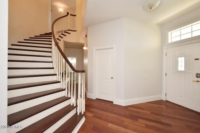 foyer with stairs, baseboards, and wood finished floors