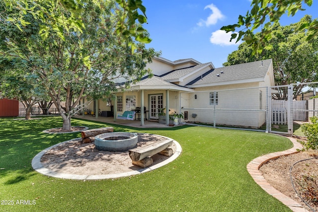 rear view of house with a fire pit, fence, french doors, a patio area, and a yard