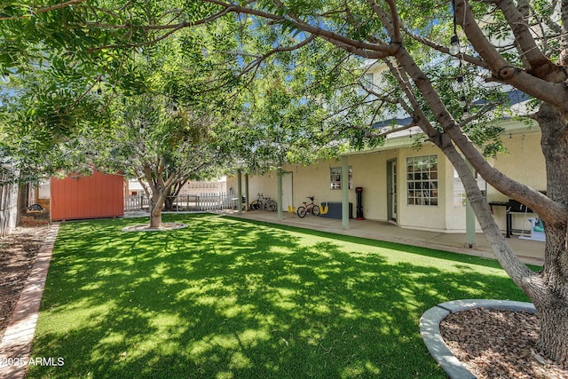back of house with a lawn, a patio area, stucco siding, and fence