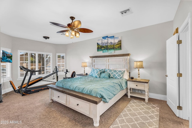bedroom featuring baseboards, visible vents, light carpet, and ceiling fan