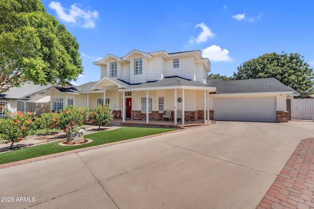 view of front facade with fence, an attached garage, a shingled roof, concrete driveway, and covered porch