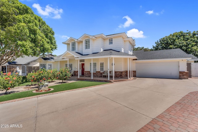 traditional home with covered porch, driveway, brick siding, an attached garage, and a shingled roof