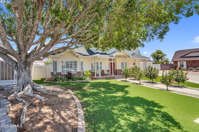 single story home featuring brick siding, a shingled roof, fence, and a front yard