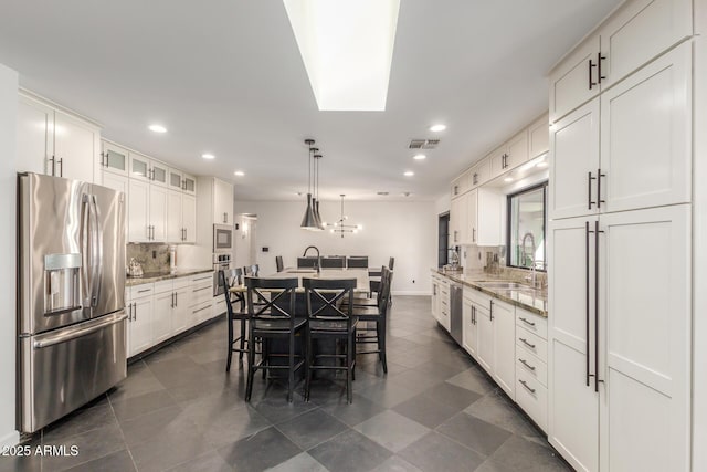 kitchen featuring white cabinetry, visible vents, appliances with stainless steel finishes, and a sink