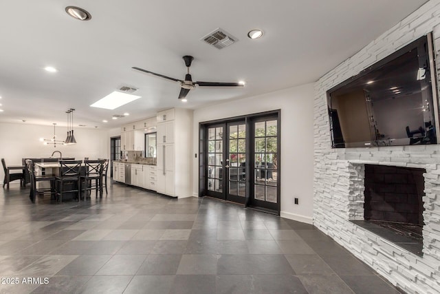 interior space with a ceiling fan, recessed lighting, visible vents, and a fireplace