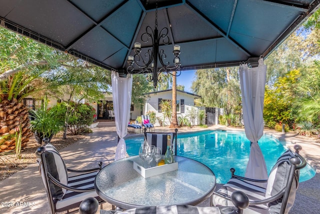 view of pool with a gazebo, outdoor dining space, a patio area, and a fenced in pool