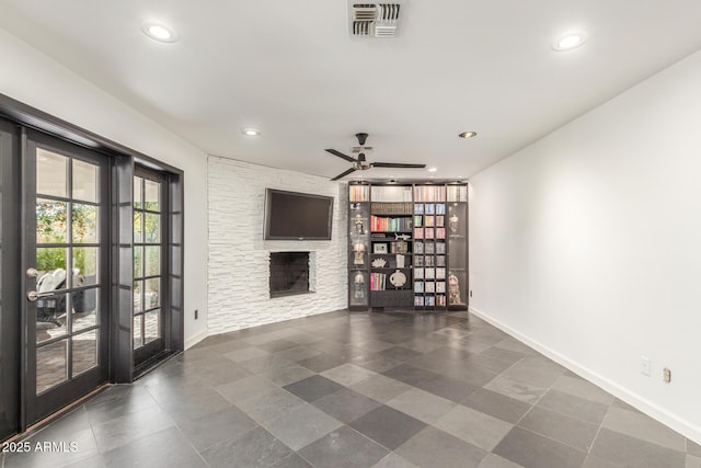 unfurnished living room with recessed lighting, visible vents, a stone fireplace, and baseboards