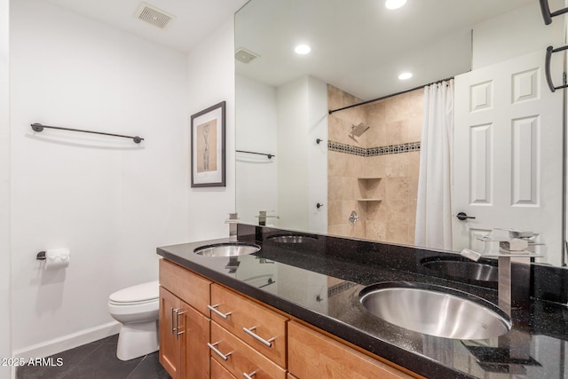 bathroom with toilet, a sink, visible vents, and tile patterned floors