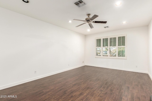 spare room with baseboards, visible vents, ceiling fan, and dark wood-style flooring