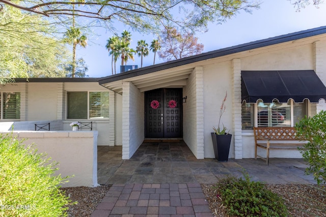 entrance to property featuring brick siding