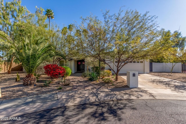 view of front of home featuring an attached garage, driveway, and fence