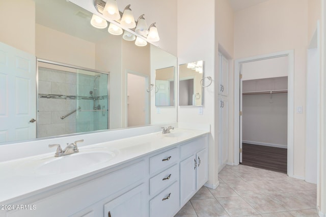 bathroom with tile patterned floors, vanity, an enclosed shower, and a towering ceiling