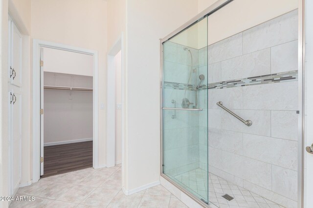 bathroom featuring tile patterned floors and a shower with shower door