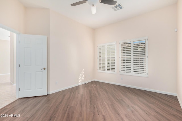 empty room with hardwood / wood-style floors and ceiling fan