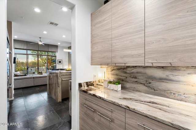 kitchen featuring decorative backsplash, light stone countertops, and ceiling fan