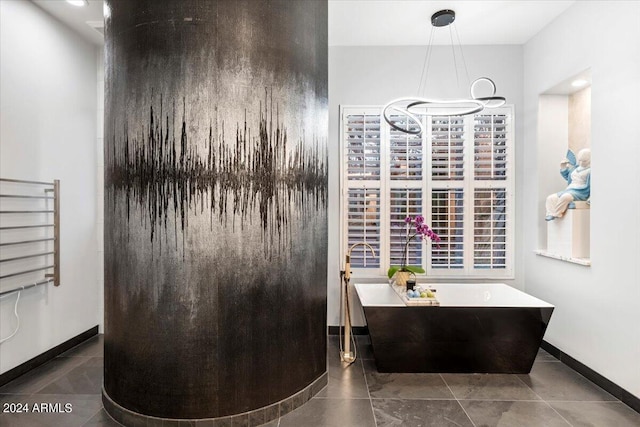 bathroom with a washtub and tile patterned flooring