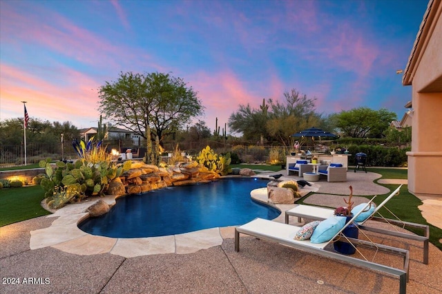 pool at dusk with a patio area