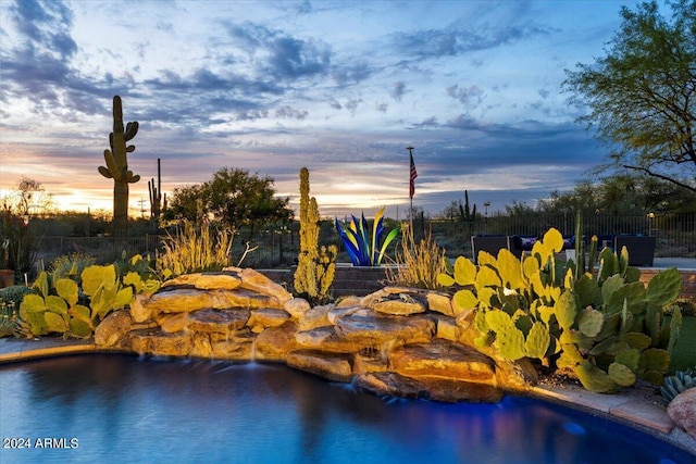 view of pool at dusk