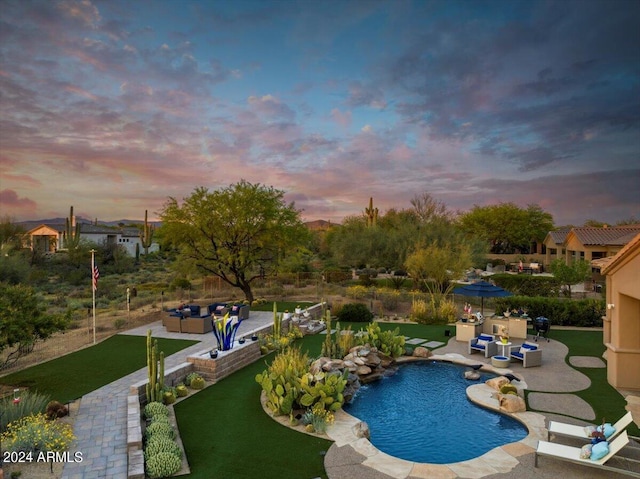 pool at dusk with a lawn, outdoor lounge area, and a patio