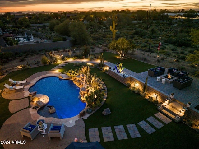 pool at dusk with a patio and a fire pit