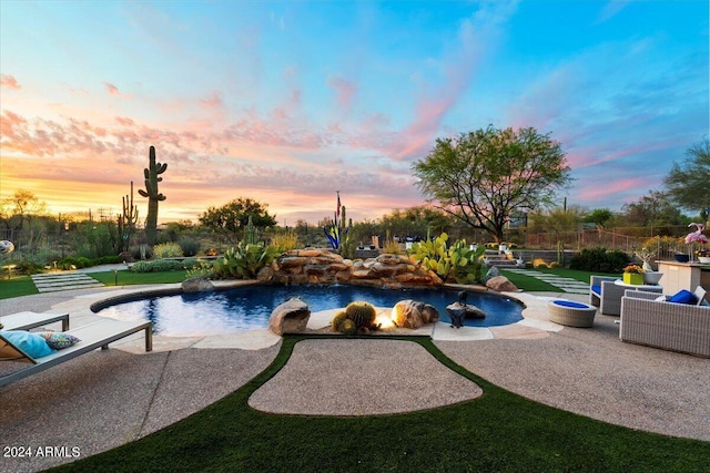 pool at dusk featuring a patio area