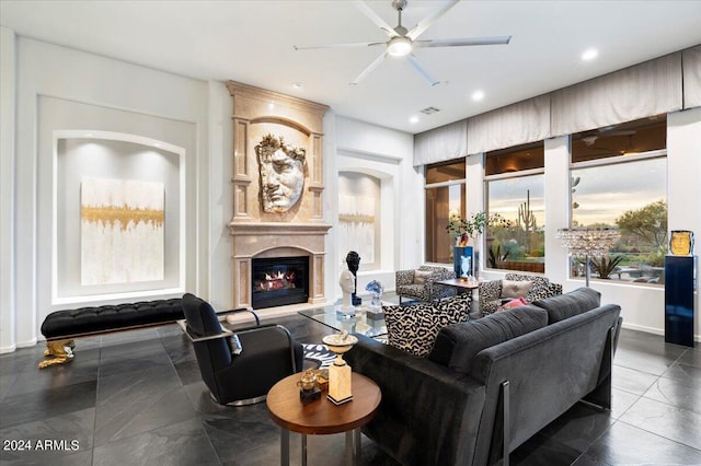 living room featuring ceiling fan and a large fireplace